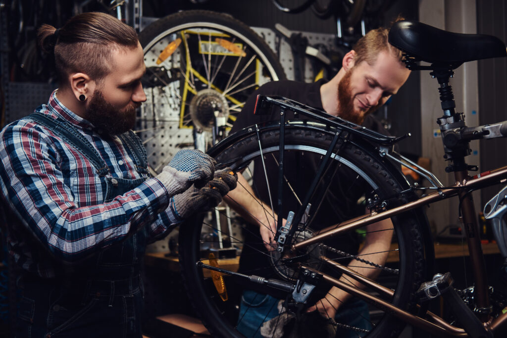 Handsome male with beard and haircut wearing jeans coverall working in a workshop